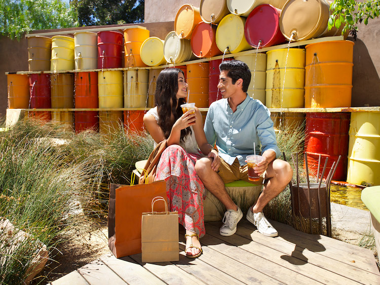 A couple drinking coffee with shopping bags at The LAB in Costa Mesa