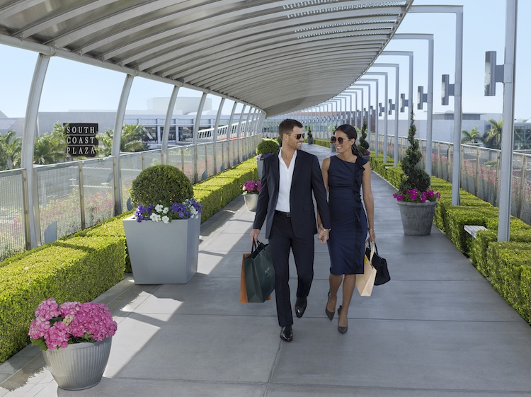 South Coast Plaza bridge with a couple holding hands and shopping bags.